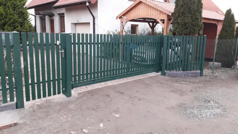 Pionowe ogrodzenie palisadowe w kolorze zielonym wzdłuż ulicy