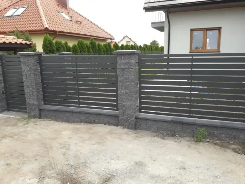 Front posesji z poziomą palisadą i słupkami z bloczków łupanych